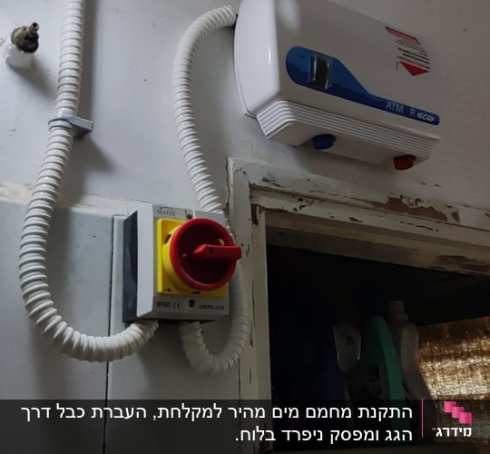 מתג חשמלי עם כבל גמיש ומכשיר חשמלי על הקיר